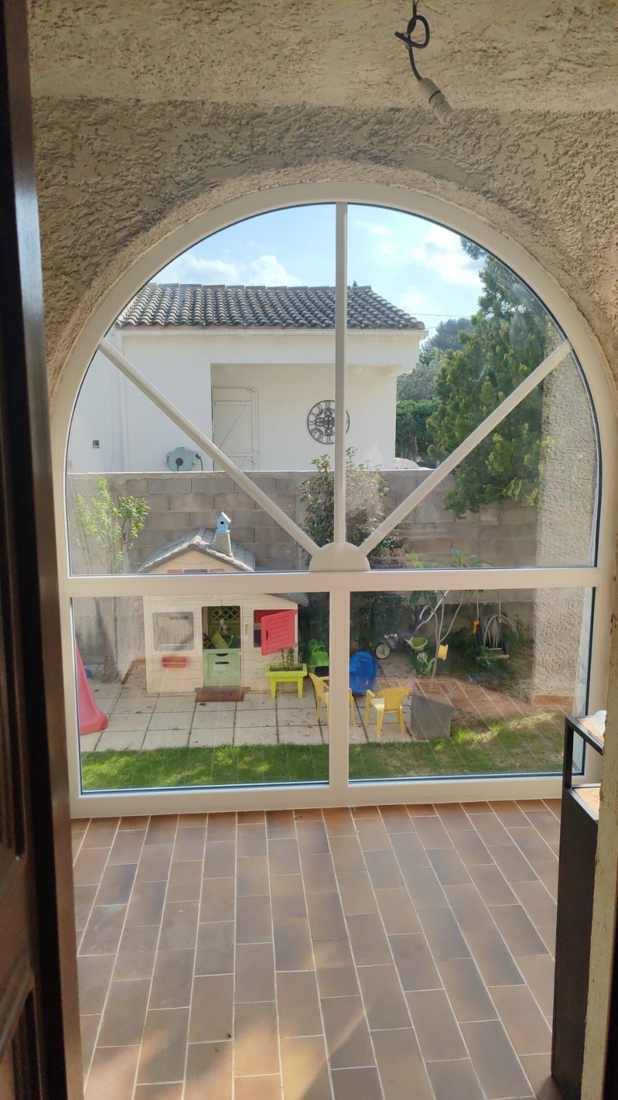 Grande fenêtre arquée donnant sur un jardin