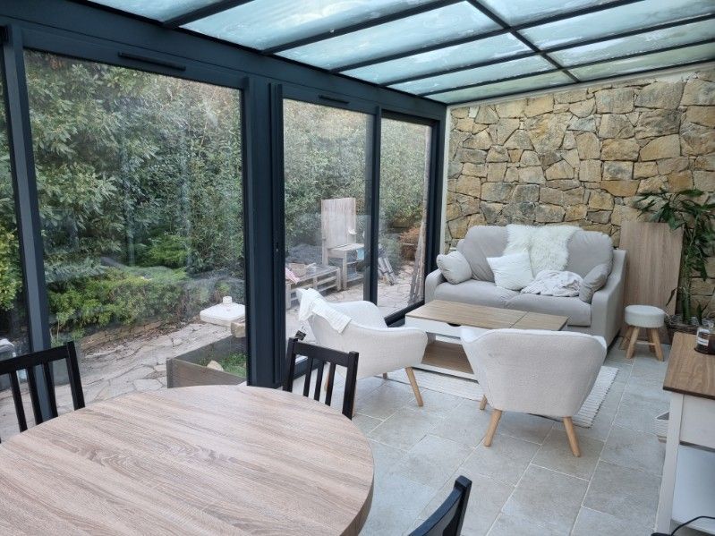 Salon d'été vitré avec mobilier blanc