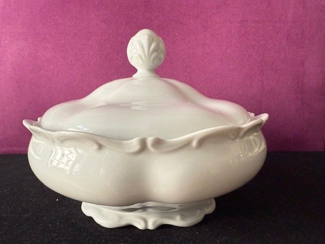 Servierschale aus weißem Porzellan mit Deckel, gewelltem Rand und Zierknauf.