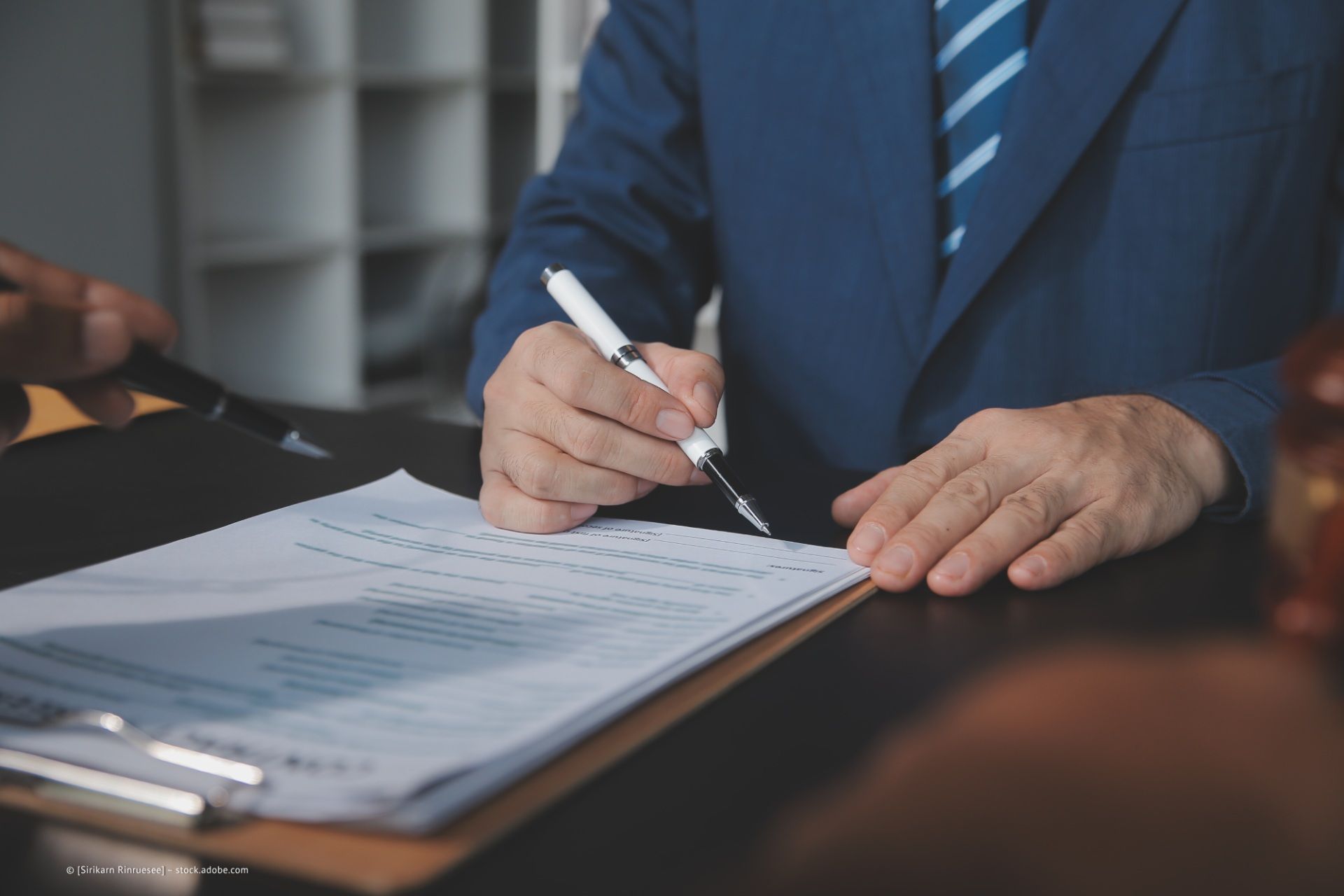 Mann unterschreibt ein Dokument