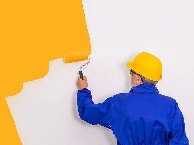 Stefan Auernheimer Malerfachbetrieb - Maler mit blauer Jacke streicht eine Wand