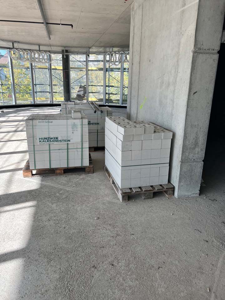 Bau HomeServices GmbH – Kalksteinziegel auf Paletten