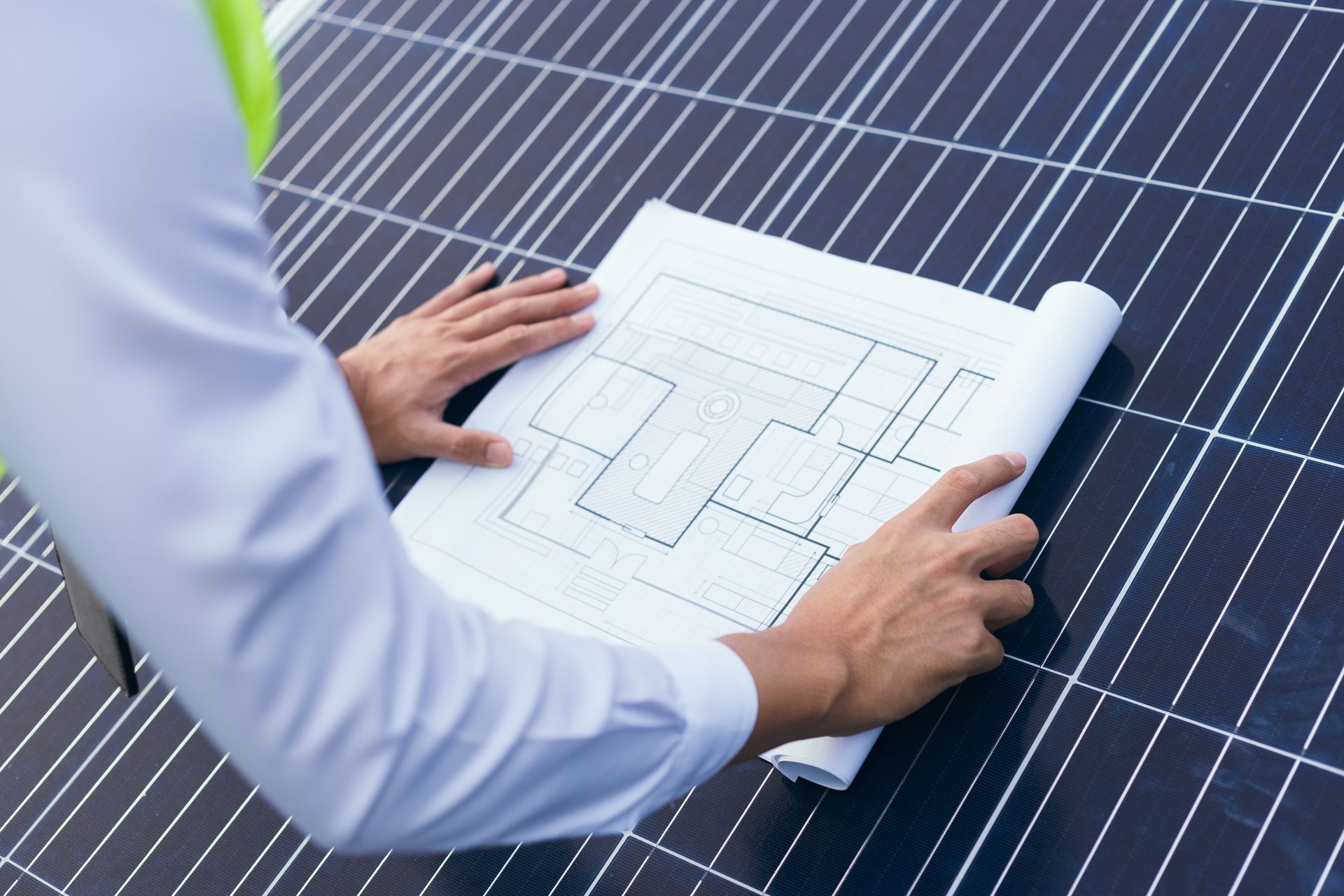 Personne examinant un plan de panneaux solaires à l'extérieur.