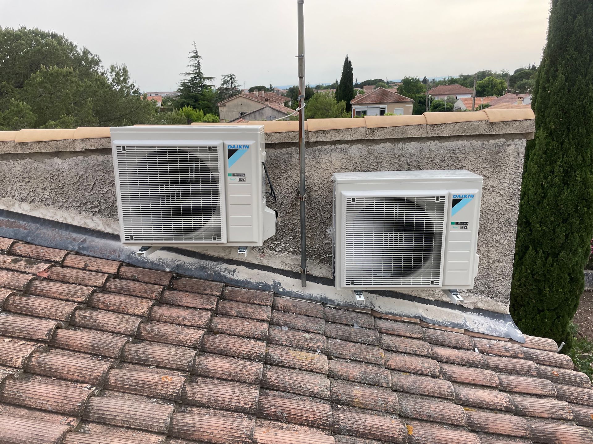 Deux unités de climatisation extérieures blanches installées sur un toit.