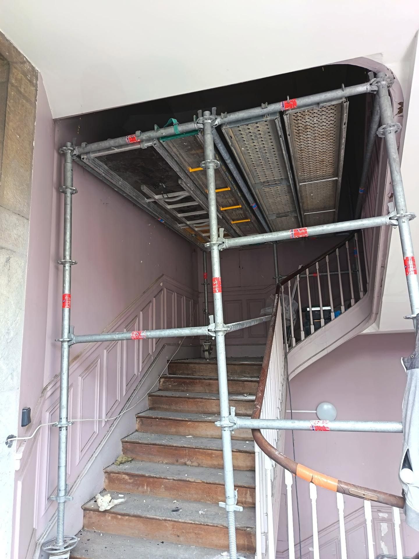 Échafaudages entourant une cage d'escalier en rénovation à l'intérieur d'un bâtiment.