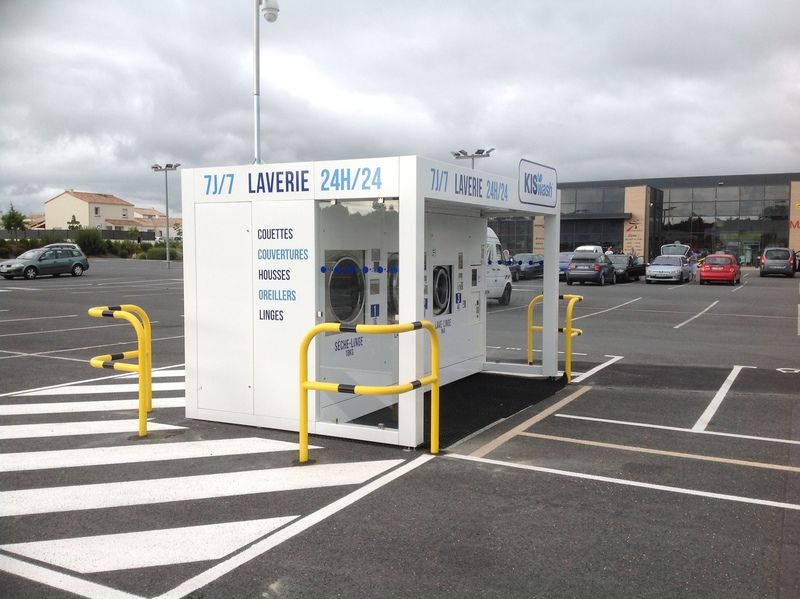 Barrières jaunes autour d'une laverie en libre-service