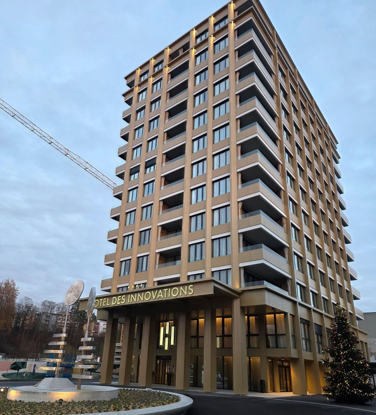 Immeuble de grande hauteur aux couleurs claires, enseigne « Hotel de l'Innovation » à sa base.
