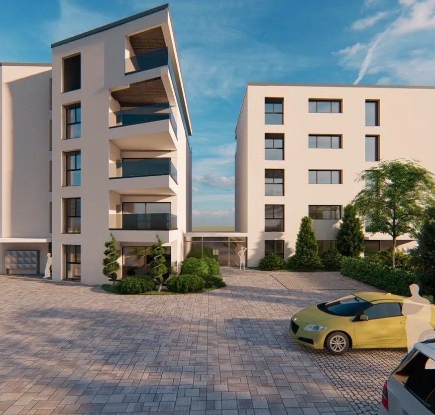 Immeubles d'appartements modernes avec une voiture jaune garée devant.