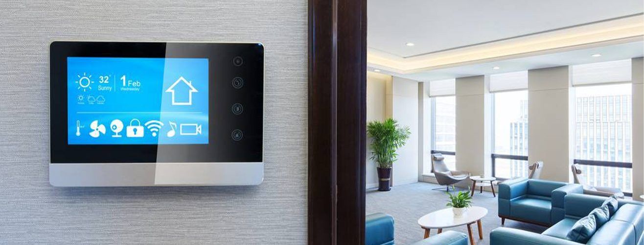 Caméra de sécurité blanche fixée sur un mur beige, orientée vers l'extérieur.