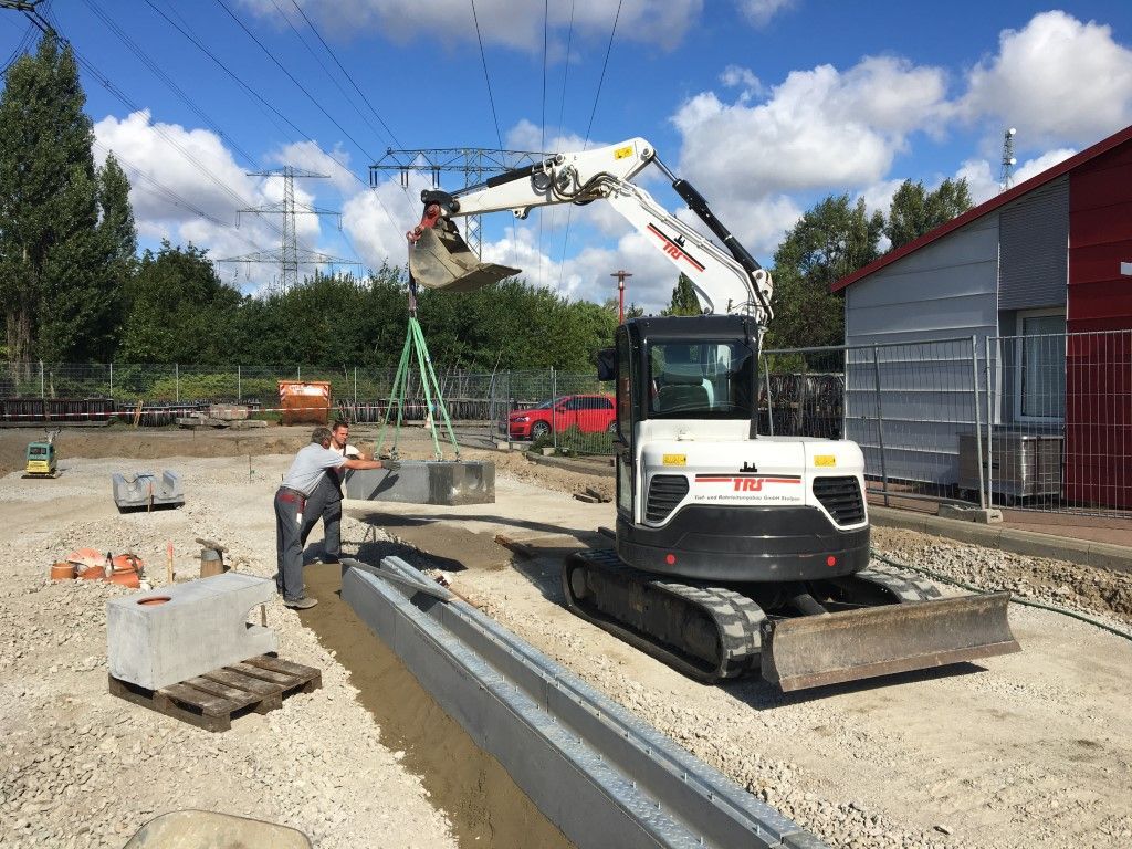 Baustelle mit Rohren und gelben Baumaschinen
