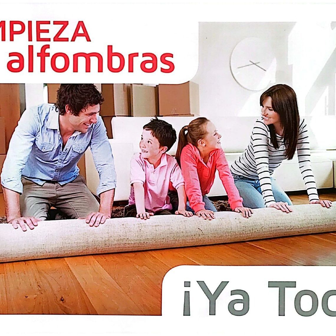 Familia desenrollando una alfombra sobre un suelo de madera, con cajas al fondo. Anuncio de limpieza de alfombras.