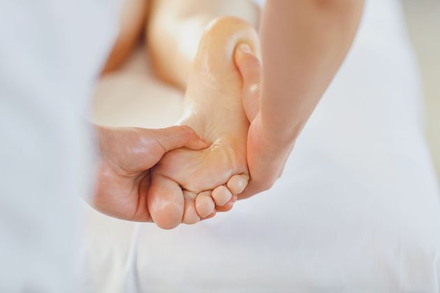Eine Person gibt einer anderen Person eine Fußmassage.