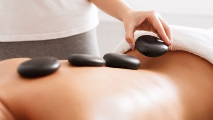 Eine Frau bekommt in einem Spa eine Hot-Stone-Massage.