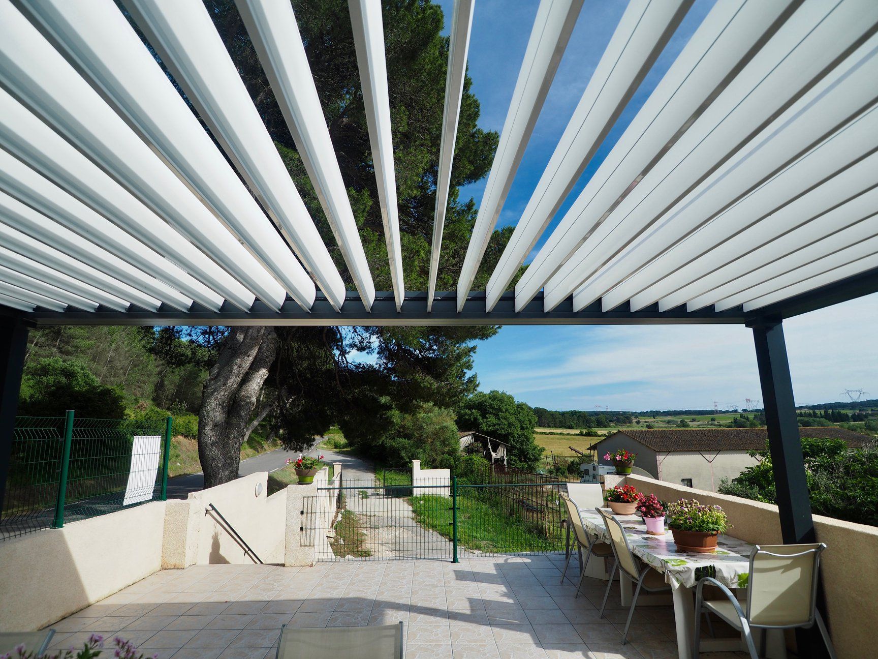 Pergola bioclimatique au-dessus d'une terrasse carrelée