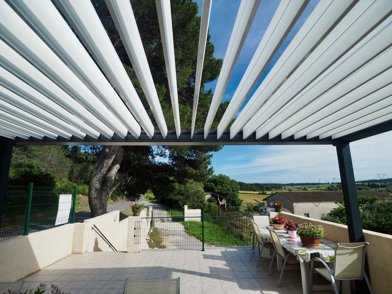 Pergolas bioclimatique au-dessus d'une terrasse carrelée