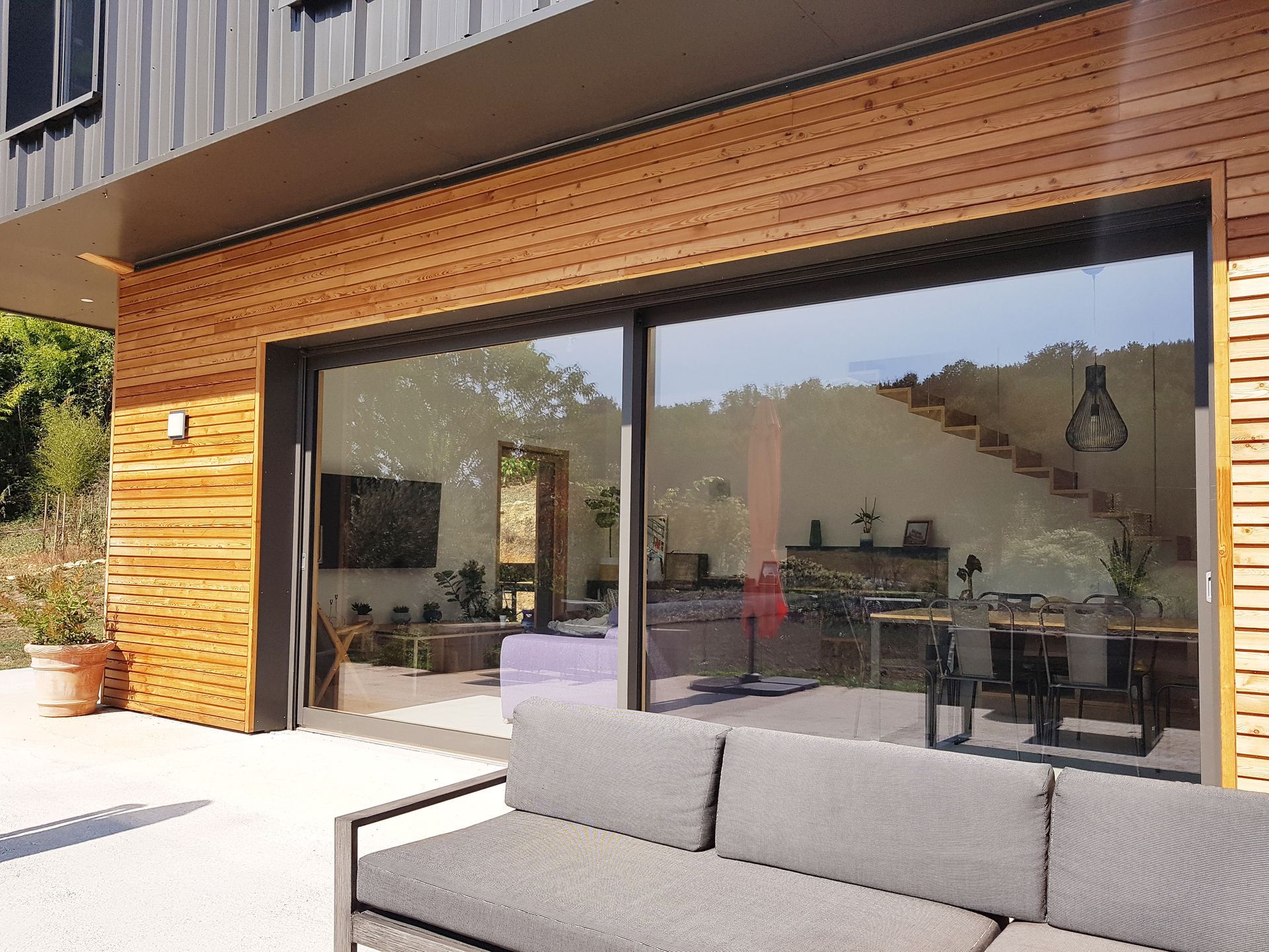 Baie vitrée sur une façade avec bardage en bois