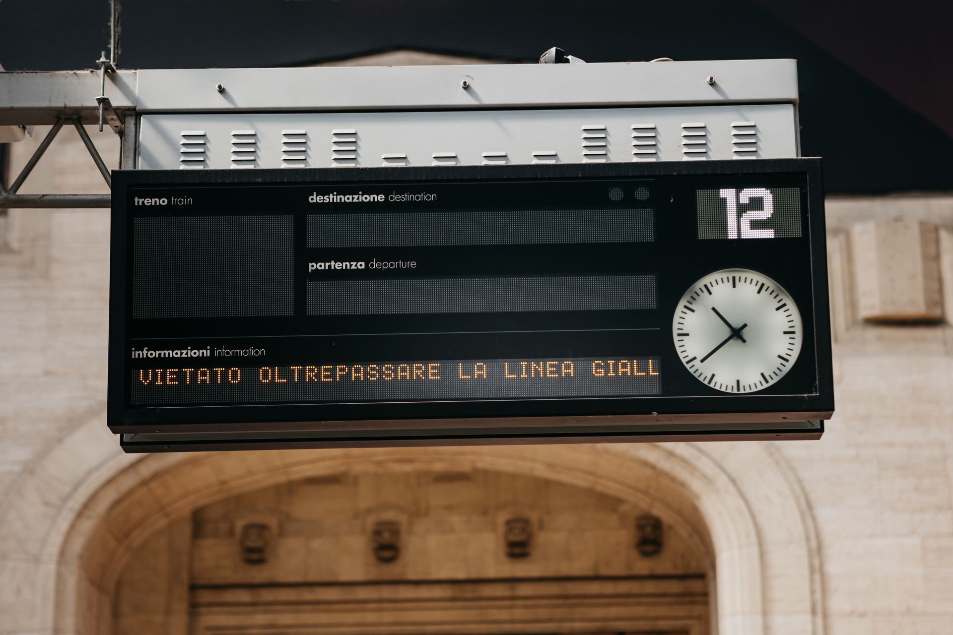 Panel de salidas de la estación de tren con reloj y visualización de texto.