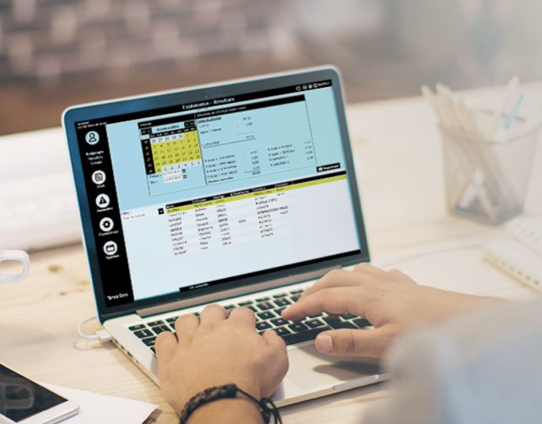 Persona que usa una computadora portátil, con las manos en el teclado, viendo una interfaz de programación de citas con un calendario.