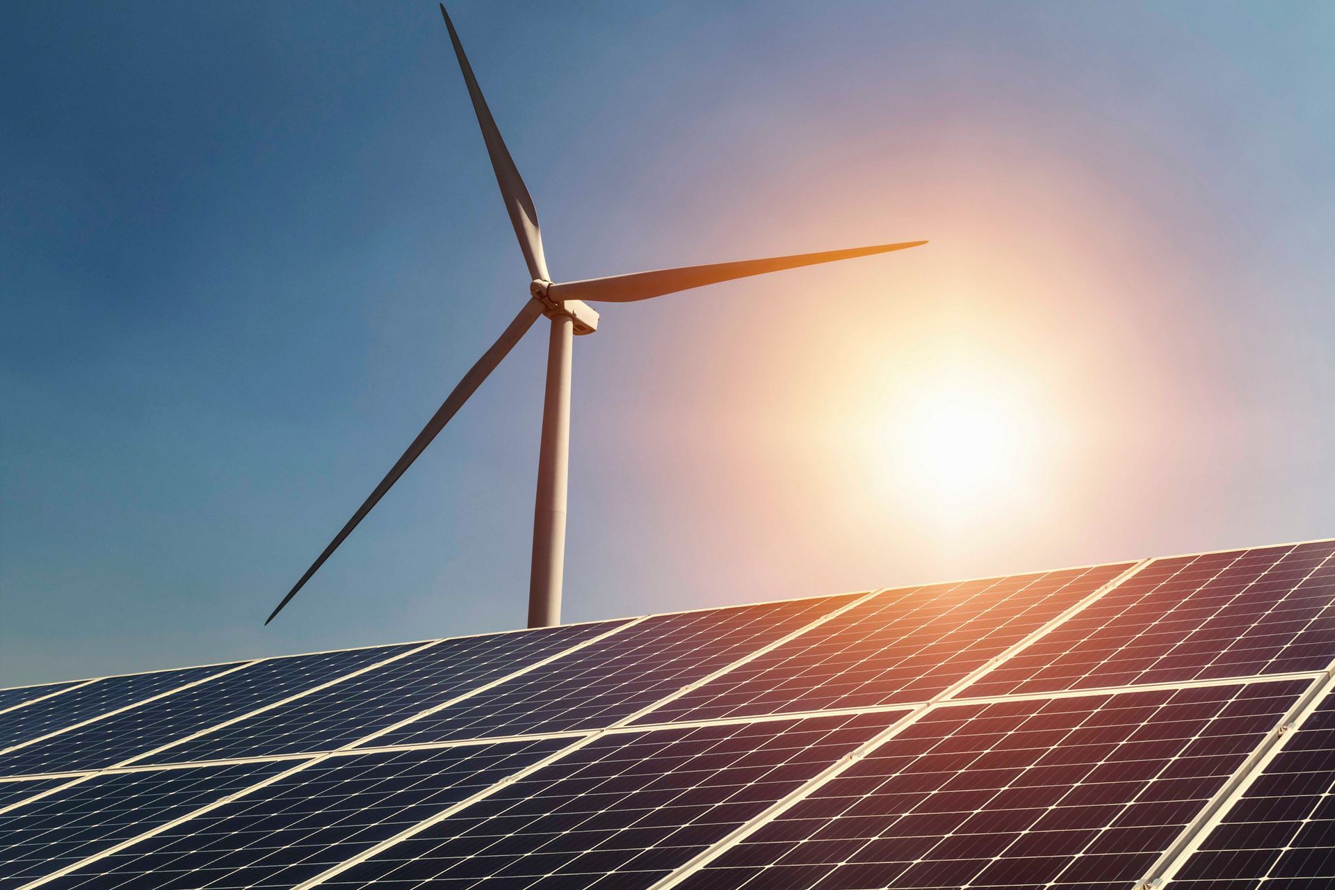 Eine Windturbine steht auf einer Reihe von Solarmodulen.