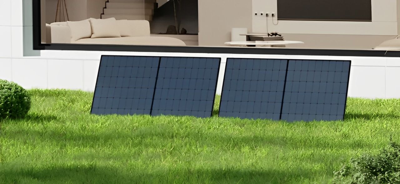 Zwei Solarmodule stehen auf einem üppigen grünen Rasen vor einem Haus.