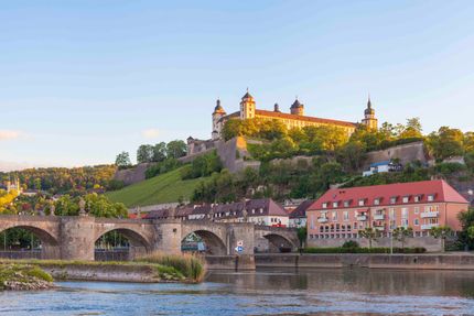 Eine Brücke über einen Fluss mit einer Burg im Hintergrund.