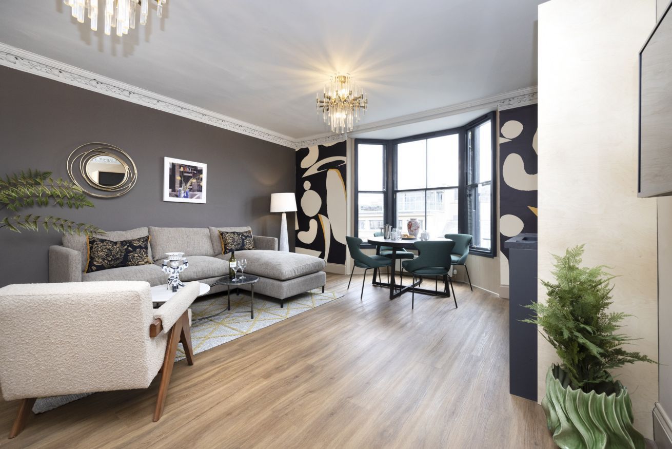 A living room with a couch , chairs and a table