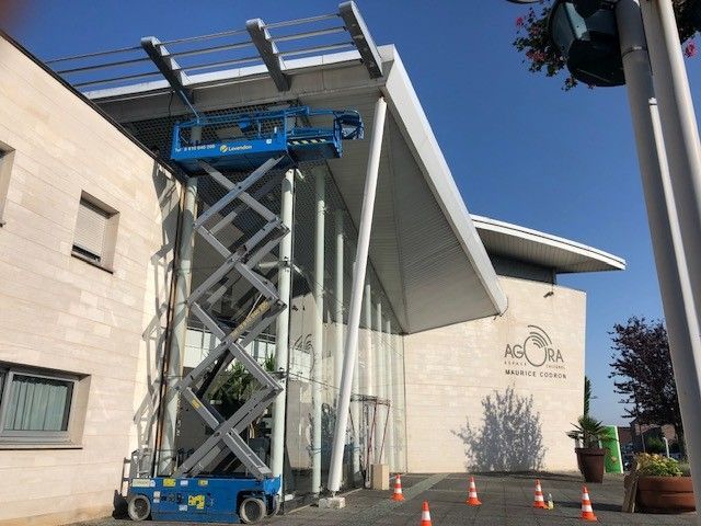 Plateforme élévatrice à l'extérieur d'un bâtiment vitré