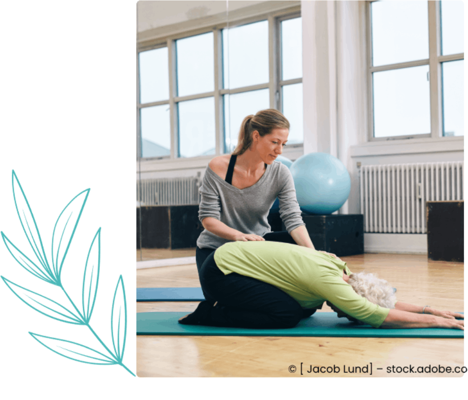 Eine Frau hilft einer älteren Frau beim Dehnen auf einer Yogamatte, Ergotherapie Praxis Anita Goetjes