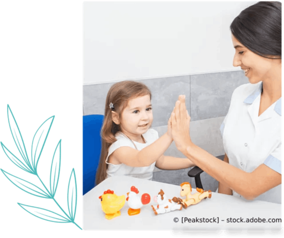 Eine Frau gibt einem kleinen Mädchen ein High Five, während sie an einem Tisch mit Spielsachen sitzt. Ergotherapie Praxis Anita Goetjes