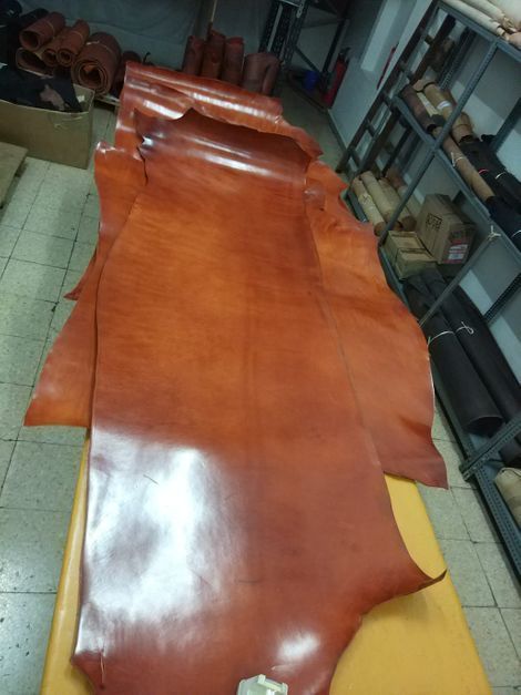 Una fila de piezas de cuero marrón sobre una mesa.