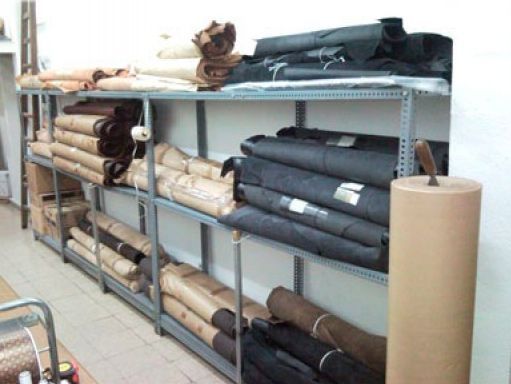 Una fila de estantes llenos de rollos de tela