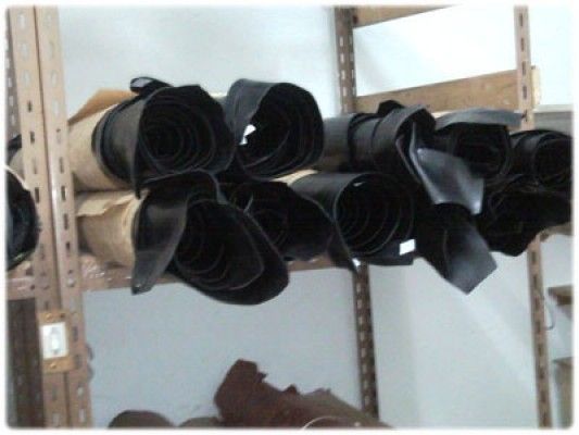Un montón de rollos de cuero negro colgados en un estante.