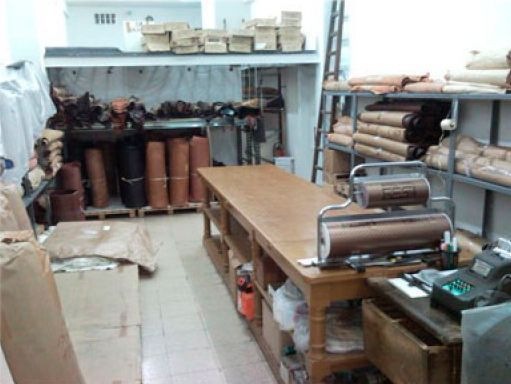 Una habitación llena de muchas cajas y una mesa de madera.