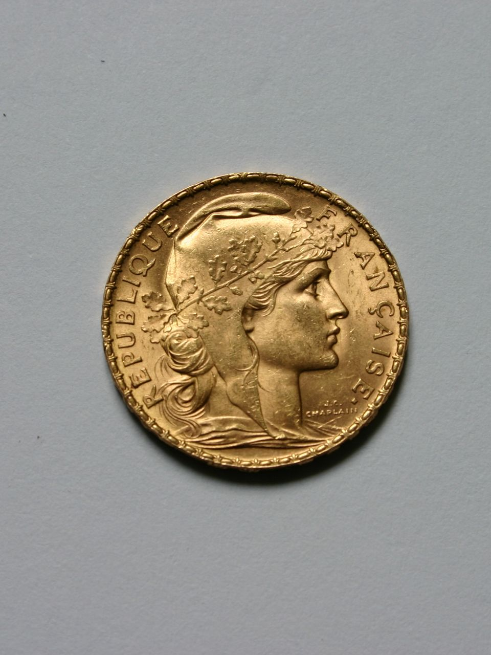 Pièce d'or représentant le profil d'une femme portant une couronne de laurier, avec RÉPUBLIQUE FRANÇAISE le long du bord.
