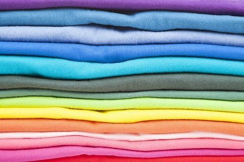 Un primer plano de una pila de camisetas coloridas.