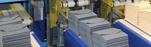 Una máquina está moviendo pilas de papel en una cinta transportadora.