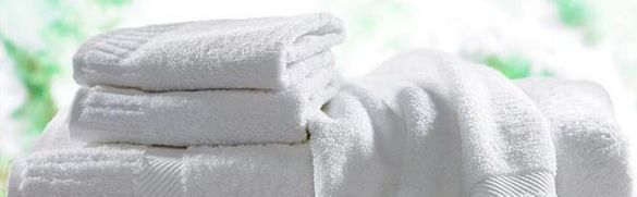 Una pila de toallas blancas colocadas una encima de otra sobre una mesa.