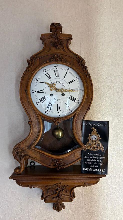 Pendule murale avec boîtier en bois.