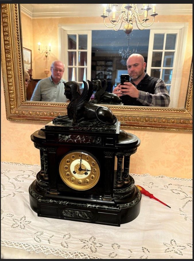 Horloge noire ornée de sphinx.