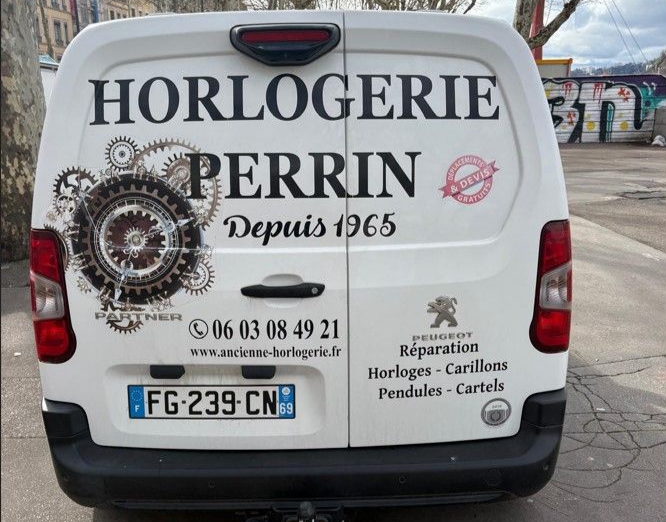 Camionnette blanche avec logo Horlogerie Perrin et motif d'engrenage d'horlogerie.
