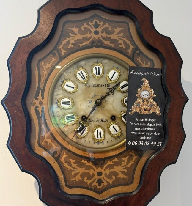 Horloge ancienne en bois au cadran orné.