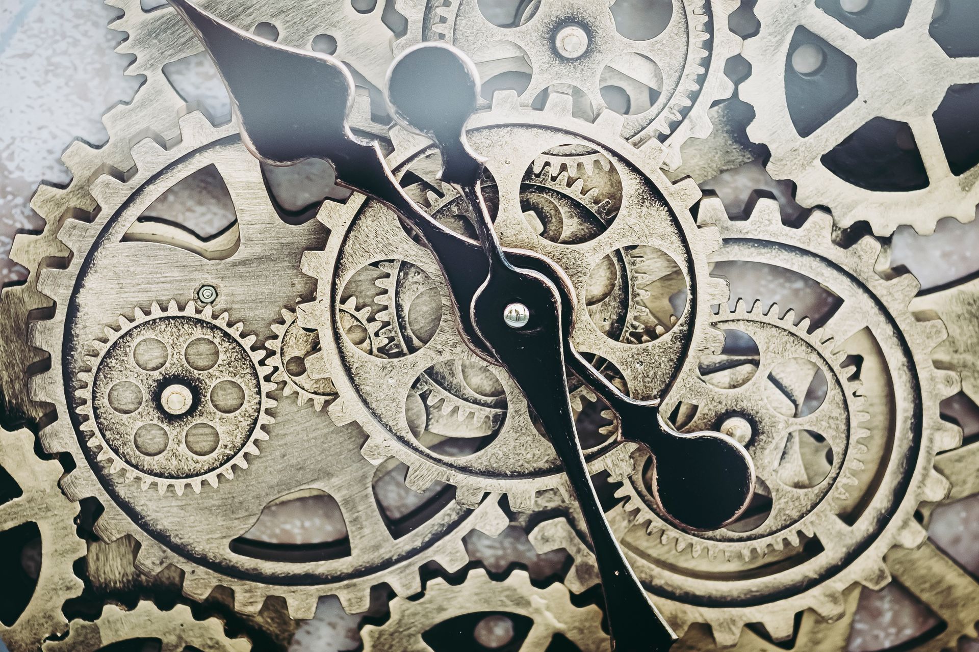 Cadran d'horloge avec engrenages apparents dans des tons or et bronze, aiguilles noires.