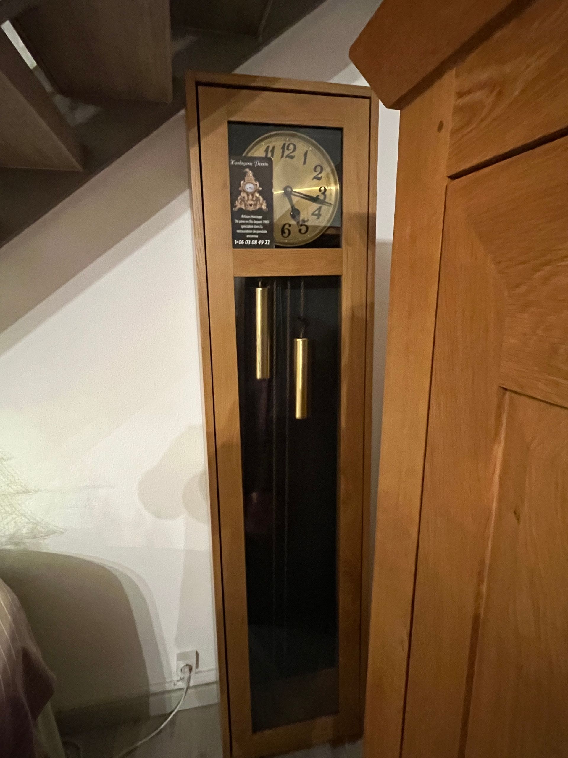 Un boîtier d’horloge contient un balancier bien visible.