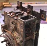 Un mécanisme d'horlogerie poussiéreux et rouillé, avant nettoyage.