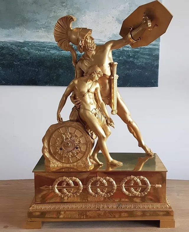 Une sculpture dorée d'un guerrier avec un bouclier.