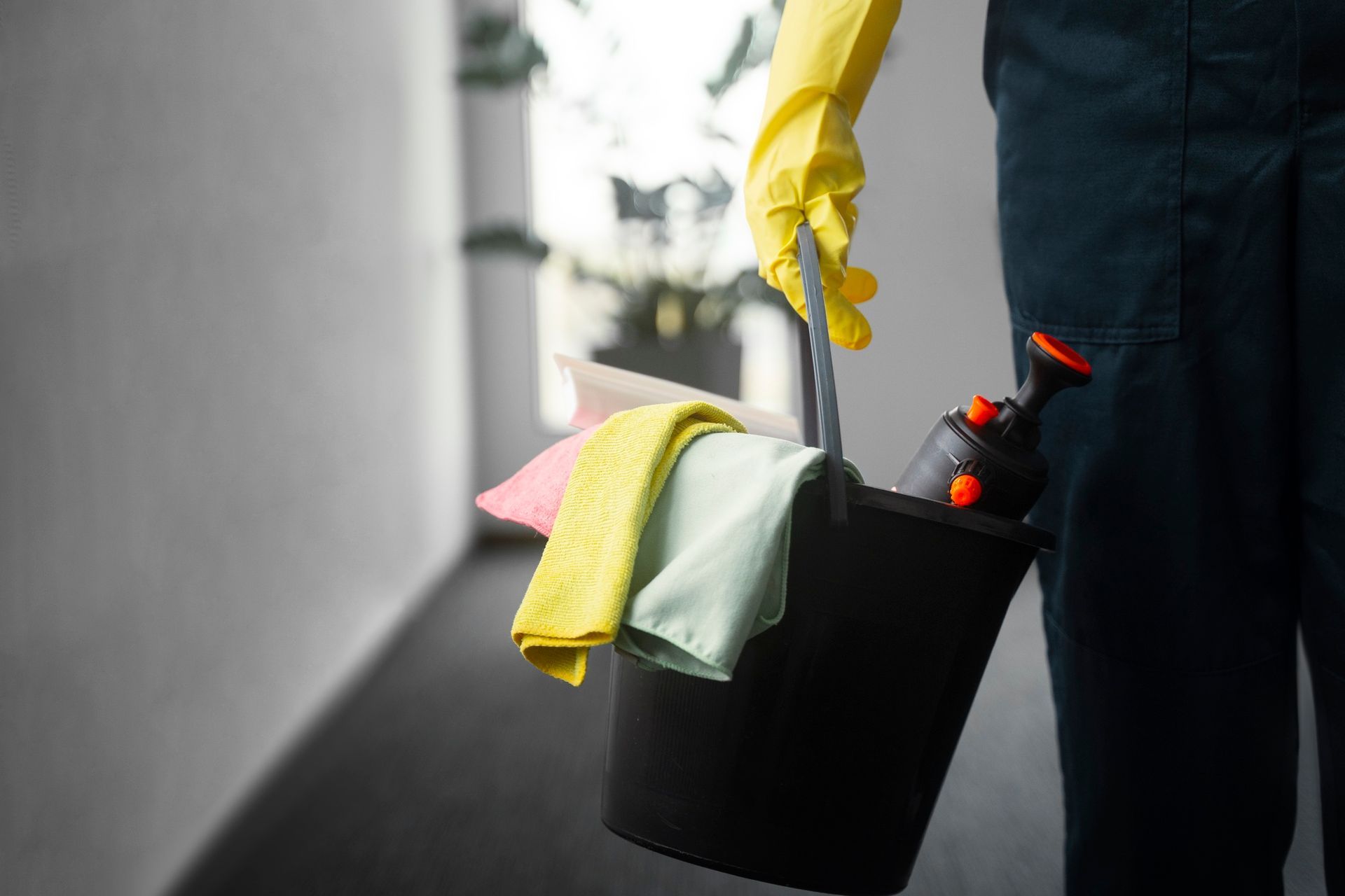Addetto alle pulizie con secchio e strumenti professionali per pulire 