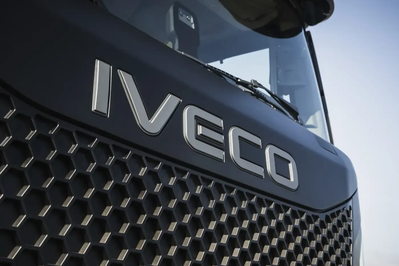 Nahaufnahme eines IVECO-LKW-Kühlergrills mit silbernem Logo auf dunkler Frontblende