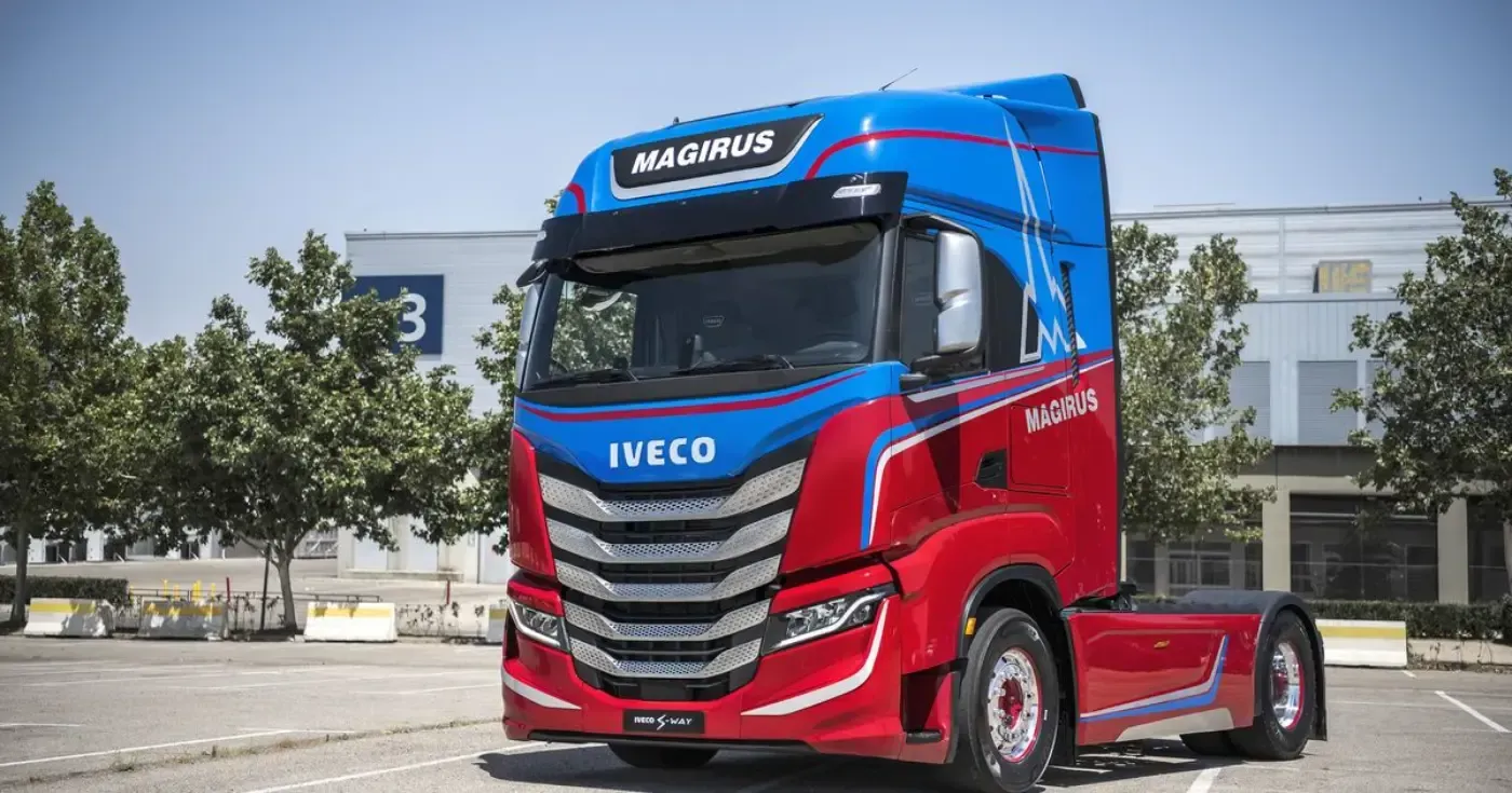 Blauer und roter IVECO-Sattelzug steht im Freien auf einem Parkplatz, Vorderansicht