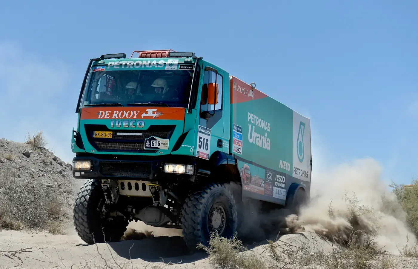 Ein Rallye-Truck rast durch den Wüstenstaub und wirbelt ihn auf.