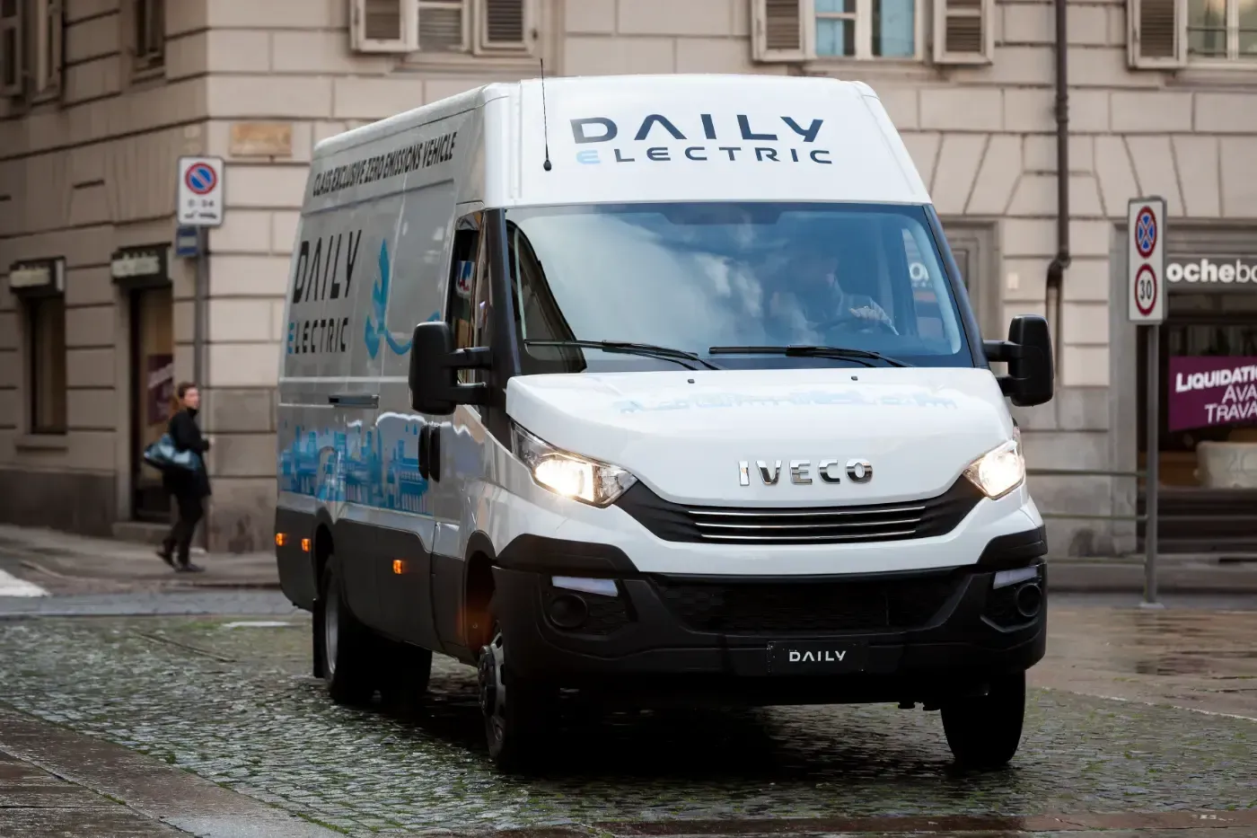 Ein weißer Lieferwagen von Daily Express fährt auf einer nassen Kopfsteinpflasterstraße in der Stadt.